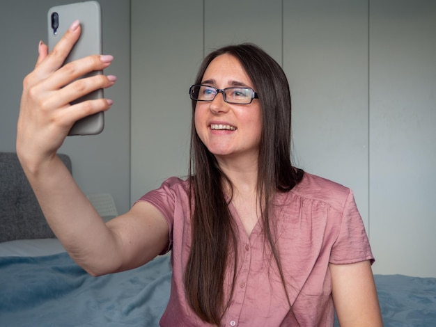 Vrouw die smartphone op het bed gebruikt