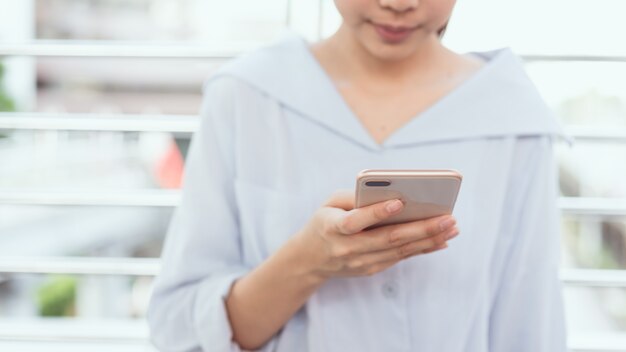 Vrouw die smartphone op trap op openbare gebieden gebruiken, tijdens vrije tijd.