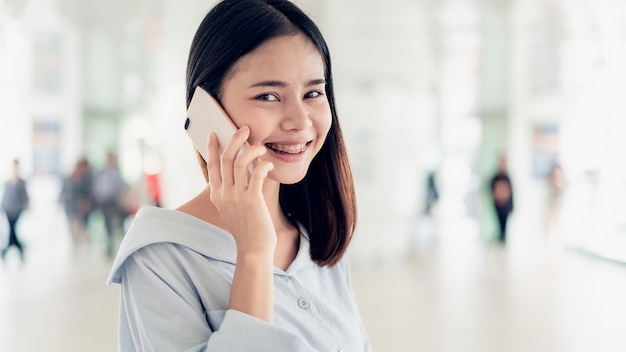 Vrouw die smartphone op trap op openbare gebieden, in vrije tijd gebruiken. Het concept van het gebruik van de telefoon is essentieel in het dagelijks leven.