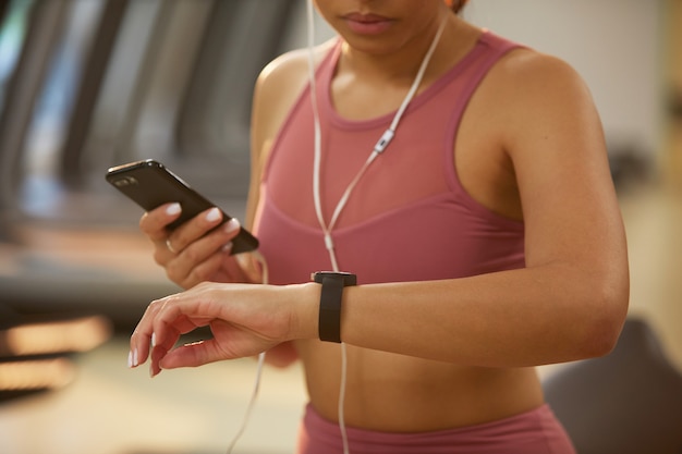 Vrouw die smartwatch in gymnastiekclose-up gebruiken