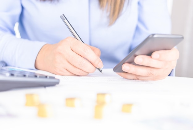 Vrouw die smatphone gebruikt die vanuit huis of kantoor werkt