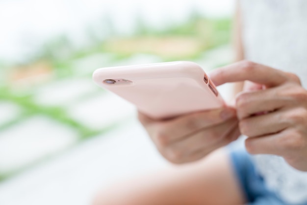 Vrouw die sms op mobiele telefoon verzendt