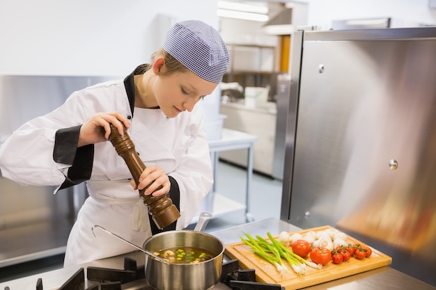 Vrouw die soep in keuken overgeeft