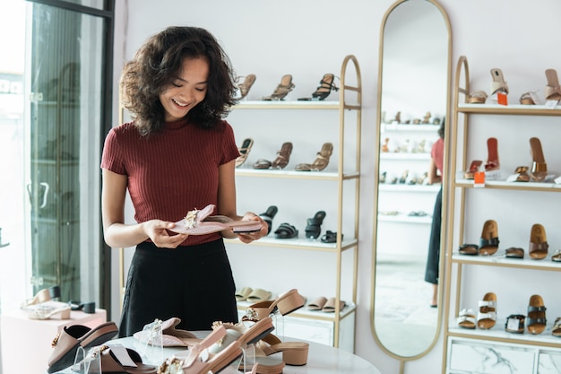 Vrouw die sommige schoenen op de planken kiest op manier slaat op