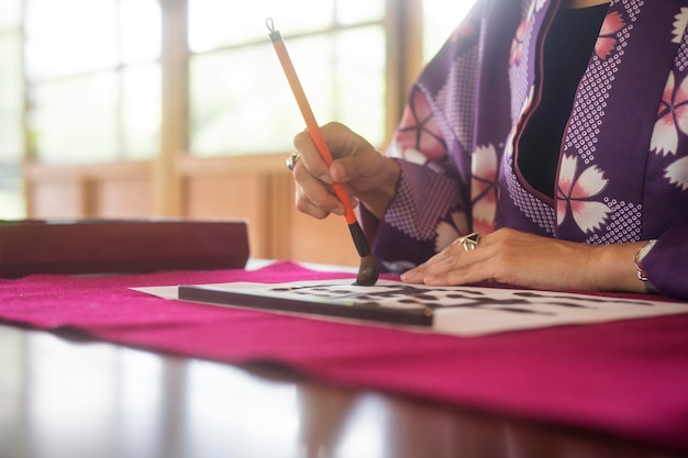 Vrouw die speciale penselen gebruikt voor japanse kunst