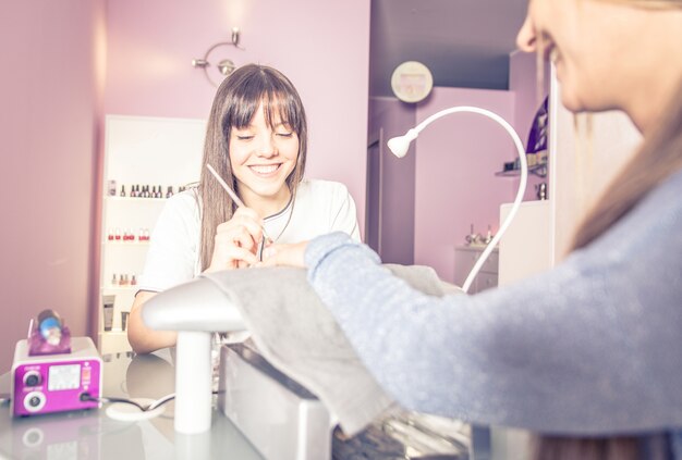 Vrouw die spijkersbehandeling in een schoonheidszaal maakt