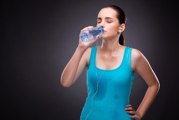 Vrouw die sporten met fles zoet water doet