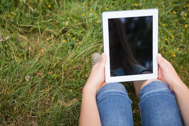 Vrouw die tablet in park gebruikt