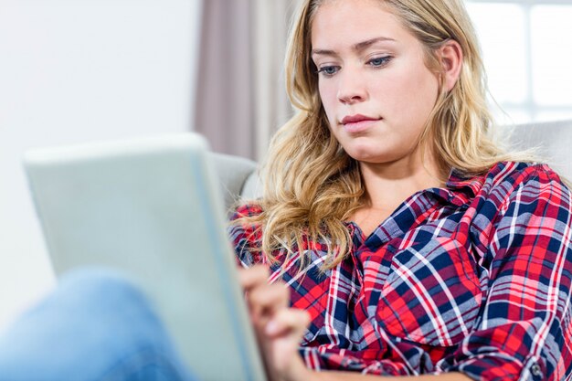 Foto vrouw die tabletcomputer op de laag met behulp van