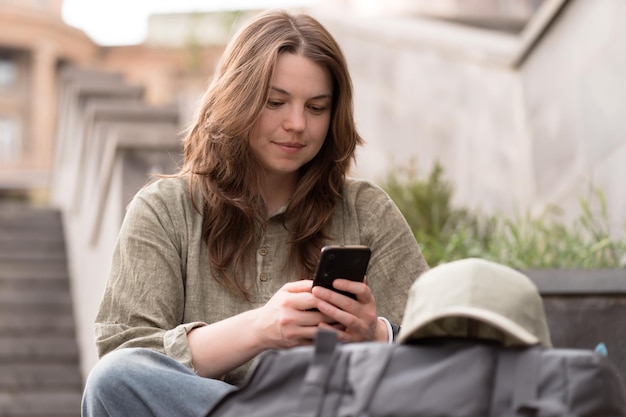 Vrouw die telefoon gebruikt om buiten te chatten