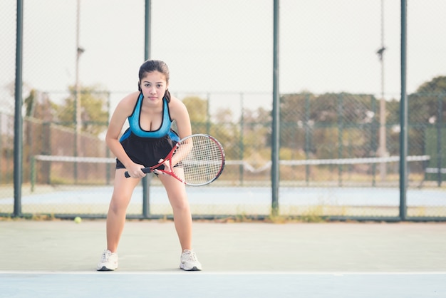 Vrouw die tennis speelt en op de dienst wacht