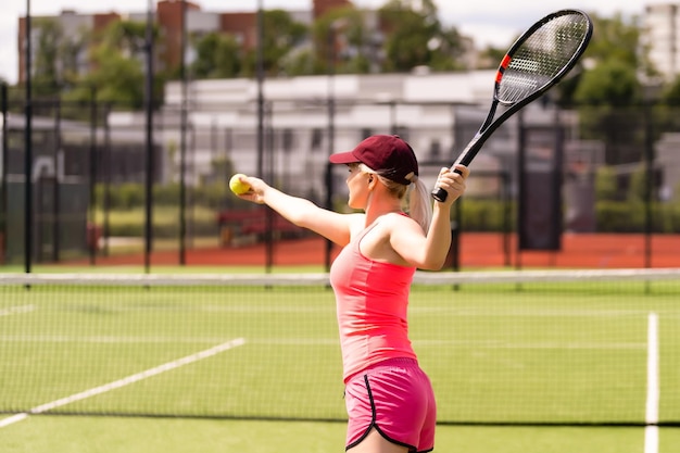 Vrouw die tennis speelt en op de dienst wacht