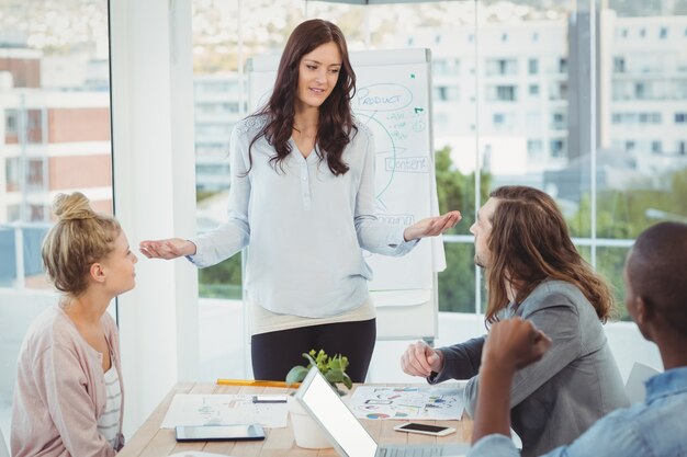 Vrouw die terwijl het bespreken met medewerkers gesturing