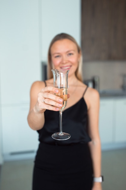 vrouw die thuis aan tafel zit met een wijnglas