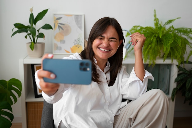 Vrouw die thuis een videogesprek voert met een smartphone