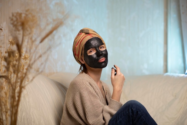 Vrouw die thuis een zwart gezichtsmasker van klei maakt