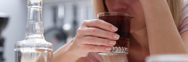 Foto vrouw die thuis in de keuken alcoholische drank drinkt