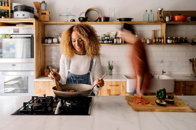 Foto vrouw die thuis in de keuken staat.