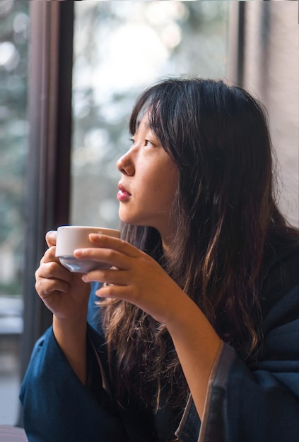 Vrouw die thuis koffie drinkt.