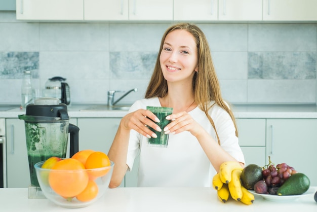 Vrouw die thuis matcha uit glas drinkt Voedingssupplementen en spirulina Gezond eten concept Smoothie menu maken Gezonde voeding smoothie ontbijt eten Gezond eten alkalisch dieet