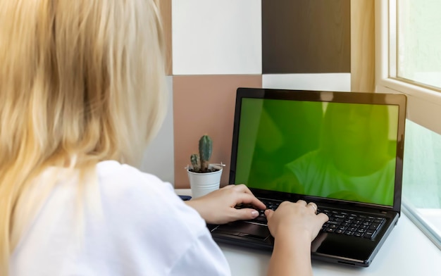 Vrouw die thuis op kantoor werkt, hand op het toetsenbord close-up Zakenvrouw met laptop leeg groen scherm