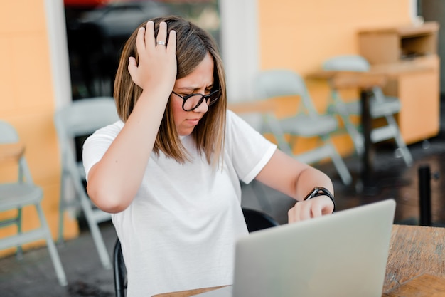 Vrouw die tijd controleert en hoofd houdt