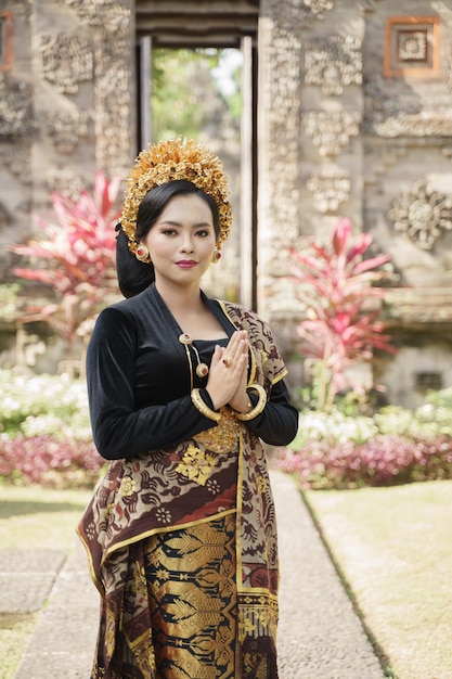 Vrouw die traditionele Balinese kleren draagt die zich welkom gebaar bevinden