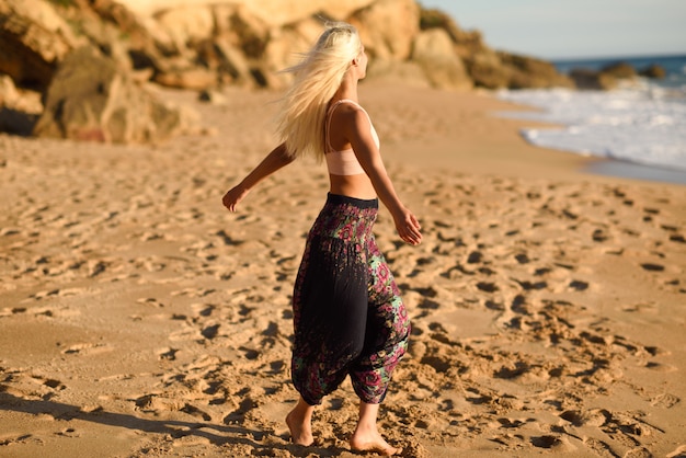 Vrouw die van de zonsondergang op een mooi strand geniet