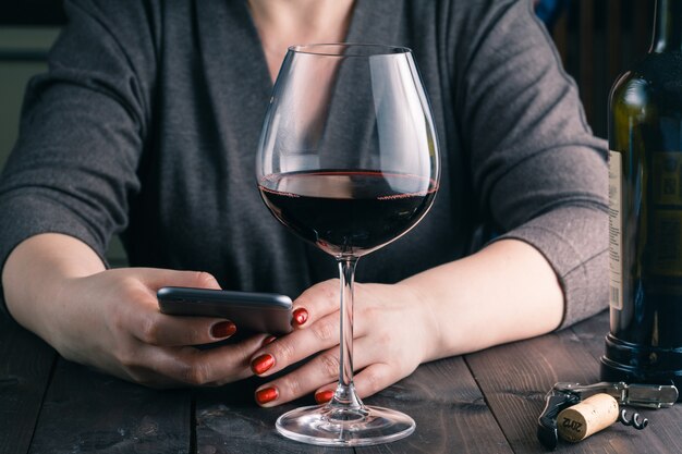 Vrouw die van een glas wijn in haar keuken geniet