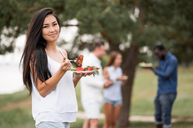 Vrouw die van het eten geniet bij een barbecue