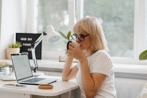 Vrouw die vanuit huis op laptop werkt