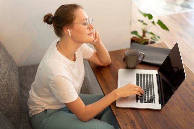 Foto vrouw die vanuit huis werkt tijdens quarantaine met laptop