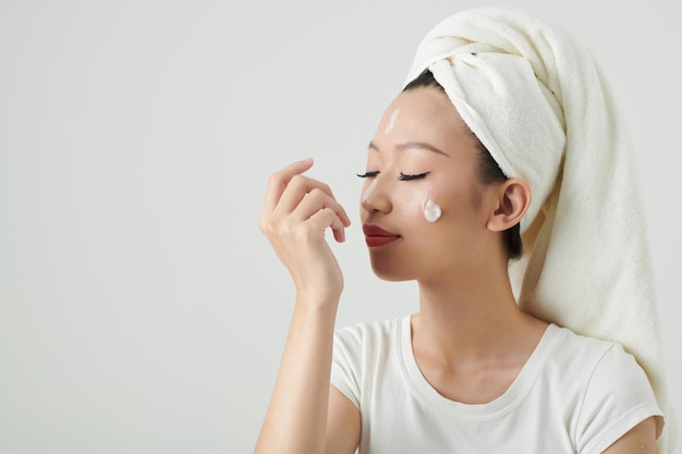 Vrouw die vernieuwende lotion aanbrengt