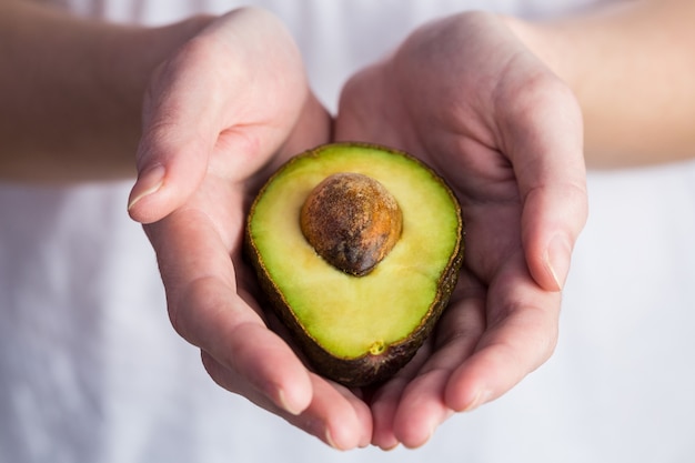 Vrouw die verse avocado toont