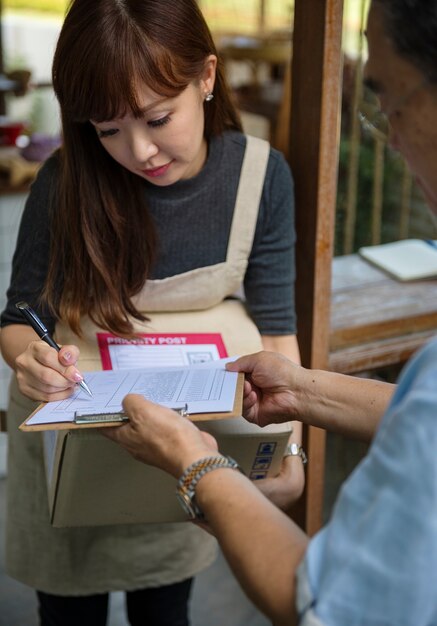 Vrouw die voor een leveringspakket ondertekent