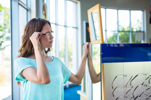 Foto vrouw die voor nieuwe glazen winkelt