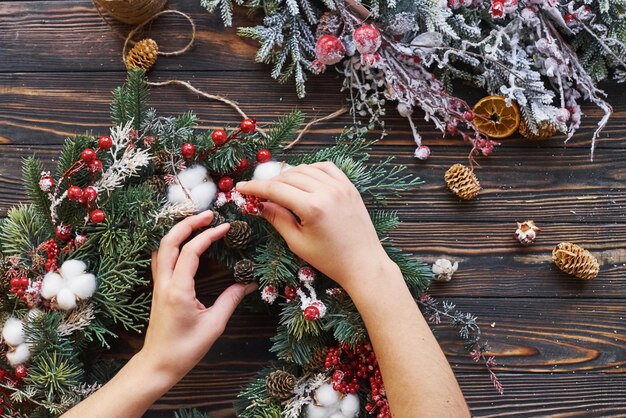 Vrouw die voor ornament zorgt. Bovenaanzicht van feestelijk kerstframe met nieuwjaarsversieringen.