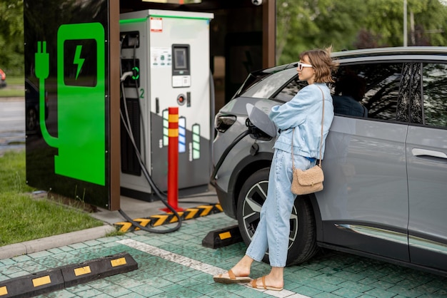 Vrouw die wacht tot haar elektrische auto wordt opgeladen