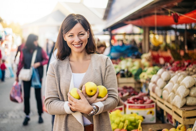 Vrouw die wat gezond voedsel koopt op groene marktplaats.