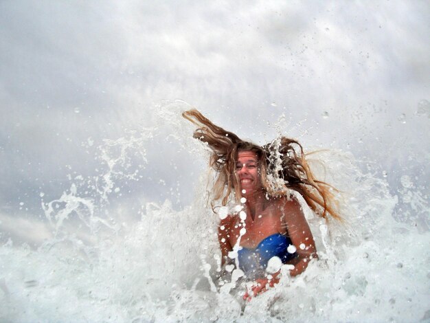 Foto vrouw die water in de zee spat