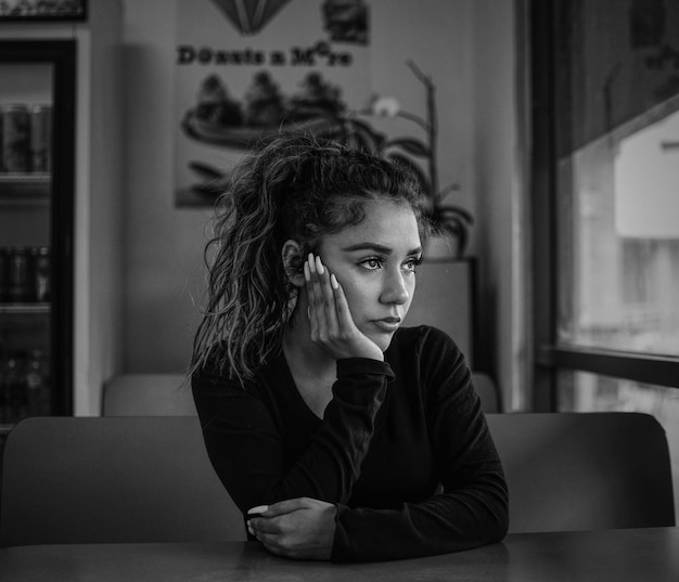 Vrouw die wegkijkt terwijl ze in een café zit