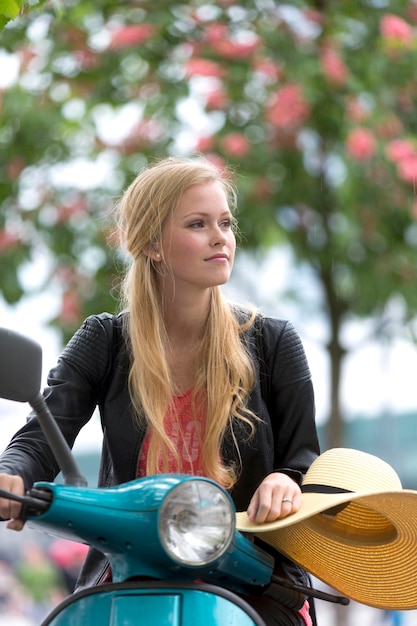 Vrouw die wegkijkt terwijl ze op een scooter zit