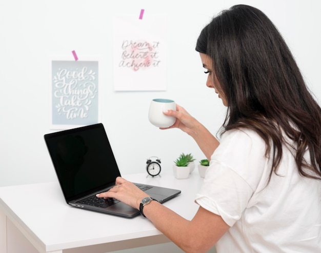 Foto vrouw die werkt als freelancer vanuit het kantoor aan huis