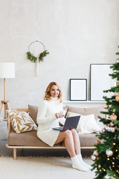 vrouw die werkt of studeert op een computer, interieur is versierd voor Kerstmis