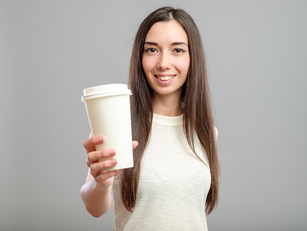 Vrouw die witte kop van koffie aanbiedt