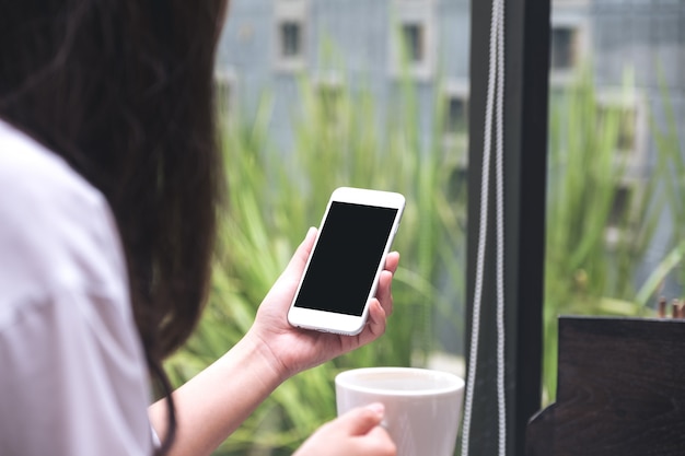 Vrouw die witte mobiele telefoon houdt