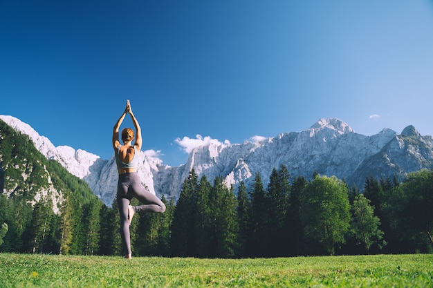 Vrouw die yoga beoefent op de natuur Jonge vrouw die yoga doet in de bergen