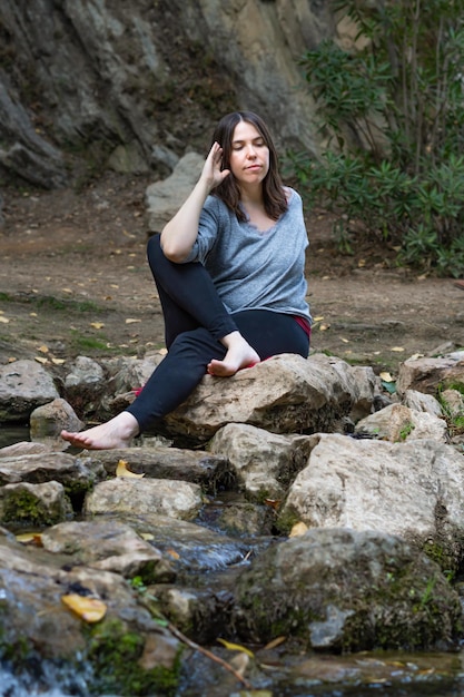 vrouw die yoga en meditatie doet in een rivier