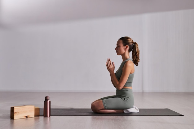 Vrouw die yoga op oefeningsmat doet