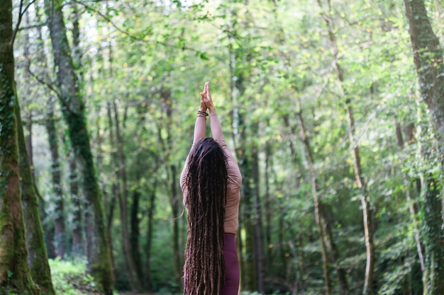 Vrouw die Yogaoefeningen doet bij het hout